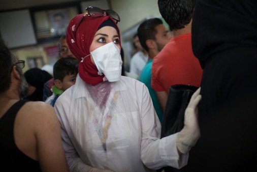 A medic at Al Razi hospital in Aleppo on Thursday, after rebel attacks killed dozens. Credit D. Walsh (NYT)