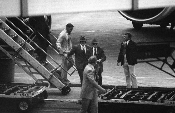 Viktor Belenko, Soviet pilot who defected by landing his super-secret fighter plane in Japan, leaves a commercial airline in Los Angeles on Sept. 9, 1976 with security agents. Source: AP