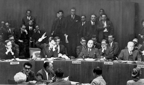 Jacob A. Malik, Soviet representative on the U.N. Security Council, raises his hand to cast the only dissenting vote to the resolution calling on the Chinese Communists to withdraw troops from Korea. Lake Success, NY. December 1950. INP. (U.S. Information Agency)